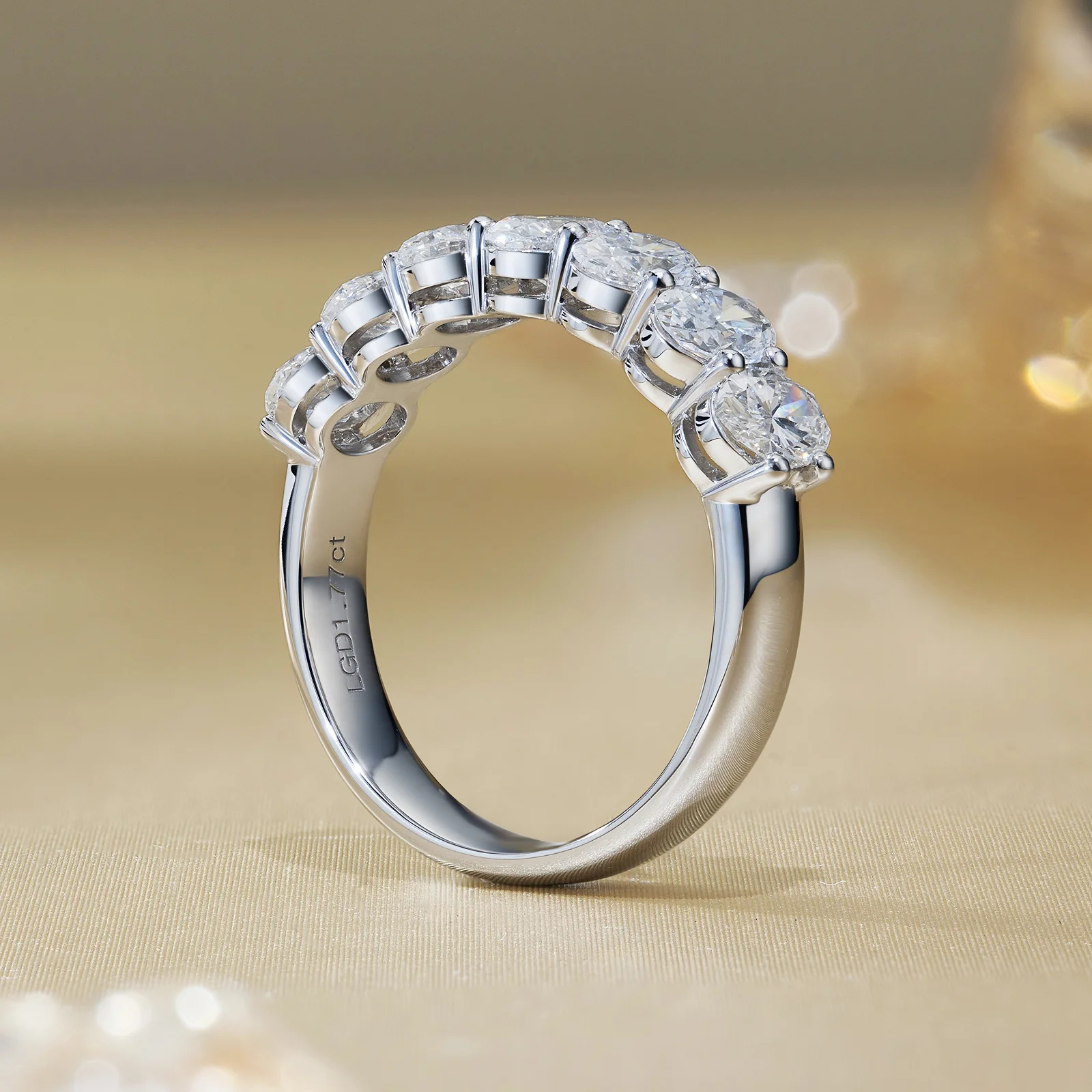 Pear shaped lab grown diamond engagement ring paired with a five-stone white gold diamond band